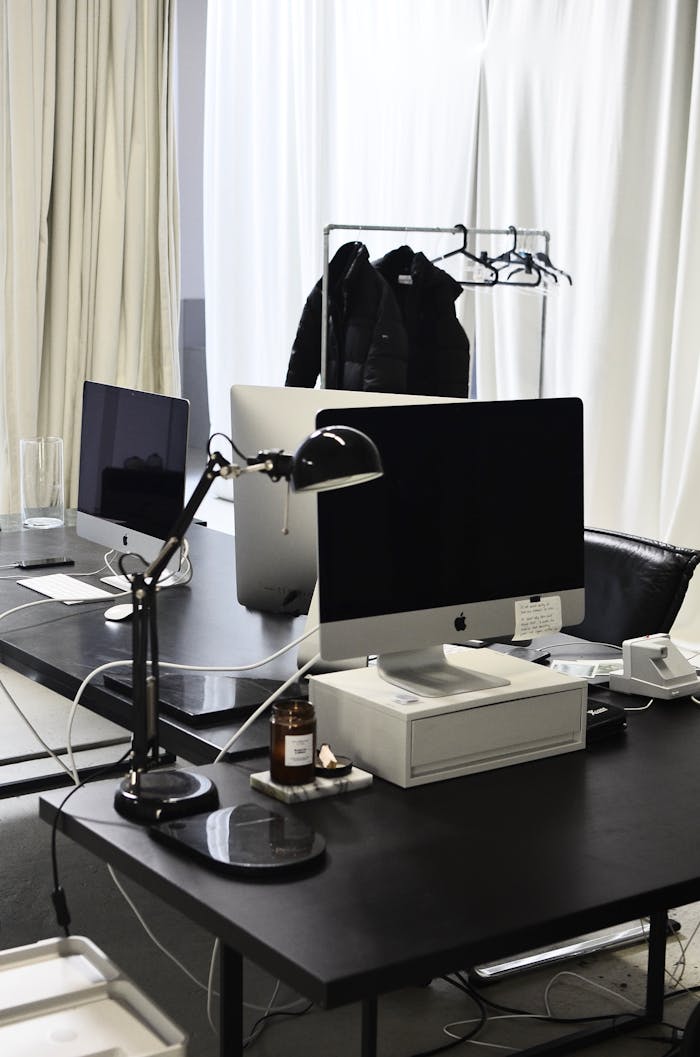 Sleek modern office with computers, lamp, and minimalistic design elements.